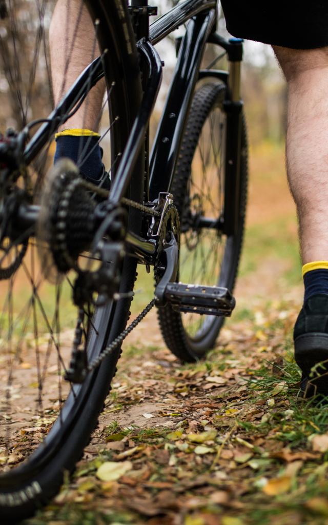 Vue resserrée d'un homme avec son pied sur la pédale d'un VTT dans la campagne