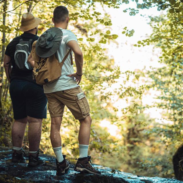 Deux hommes, sac sur le dos, contemplent la nature pendant leur randonnée