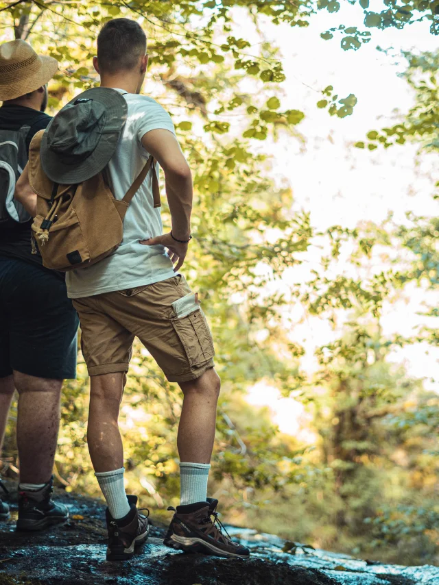 Deux hommes, sac sur le dos, contemplent la nature pendant leur randonnée